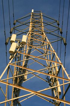 Top of the electricity pylon over blue sky.
