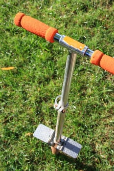 Close up of a pogo stick on a green grass.
