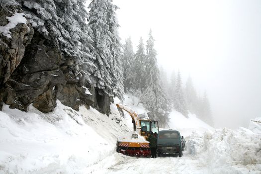 Snowplow in action on rural snow covered road. Winter in Balkans Mountain - Kosovo