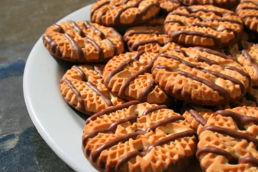 Close up of chocolate striped shortbread cookies on a plate.
