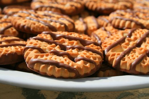 Close up of chocolate striped shortbread cookies on a plate.
