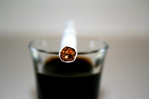 Close up of a cigarette on a glass.
