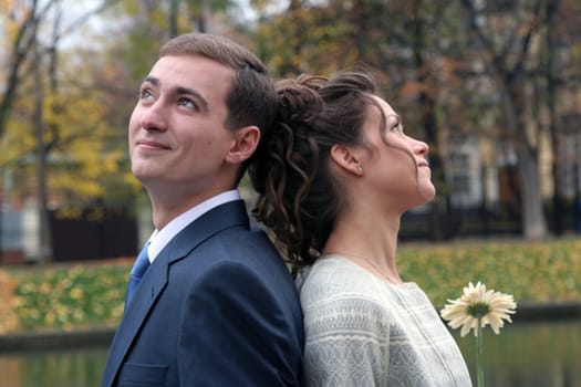 The groom and the bride walk in park in the autumn