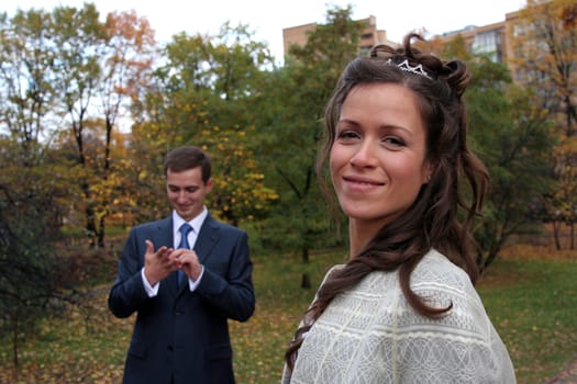 The groom and the bride walk in park in the autumn