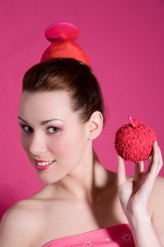 Girl in pink holding up a pink apple