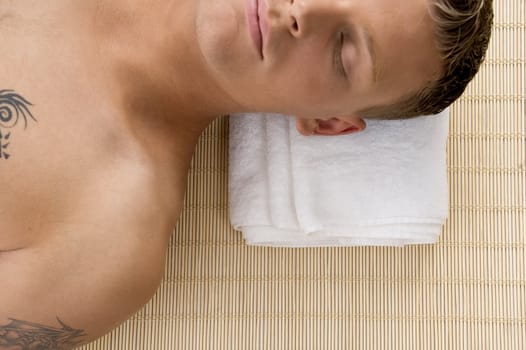 man relaxing with his eyes closed at spa against white background