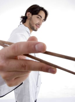young fellow in chef uniform holding chopsticks on an isolated white background