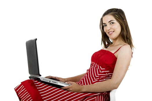 Portrait of a young beautiful woman seated on a chair with a laptop - isolated on white