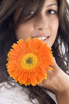 close up of beautiful model with orange gerbera against white background
