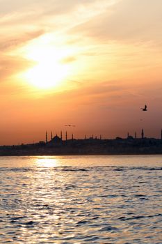 The view of Blue Mosque and Hagia Sofia across Bosporus during sunset. Istanbul, Turkey