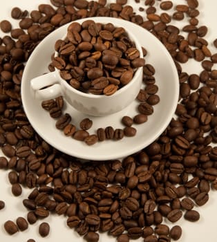 White china cup with roasted coffee beans. Selective focus