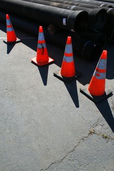 A row of road cones next to a construction site.
