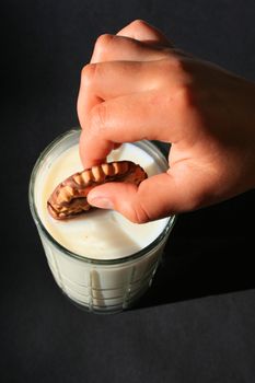 Close up of a cookie and a glass of milk.
