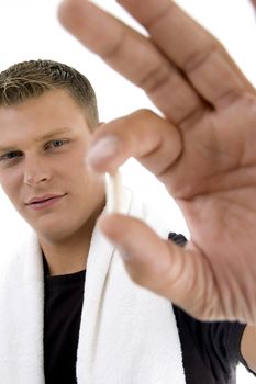 young man showing pill against white background