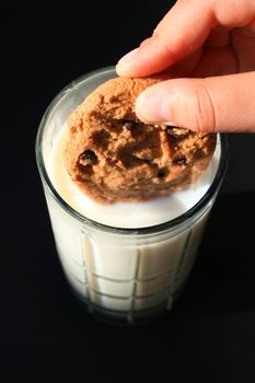 Close up of a cookie and a glass of milk.
