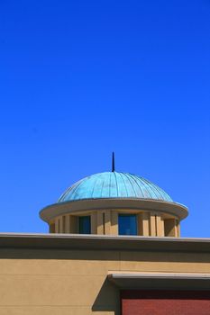 Close up of a dome over blue sky.
