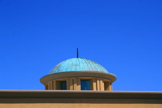 Close up of a dome over blue sky.
