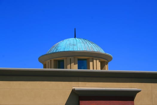 Close up of a dome over blue sky.
