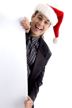 executive in christmas hat peeping through placard isolated on white background