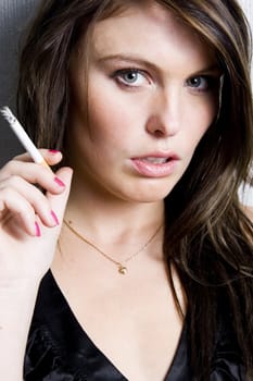 Portrait of beautiful young fashion model smoking a cigarette