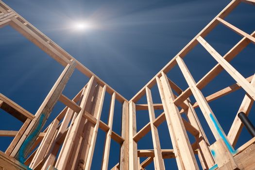 New Construction Framing Abstract with Sunburst Over Clear Blue Sky.
