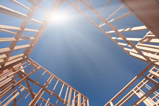 New Construction Framing Abstract with Sunburst Over Clear Blue Sky.