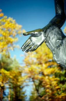 Open hand of park sculpture on autumn background