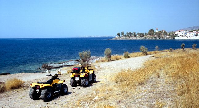 Quadracycles on the shore with town and sea background