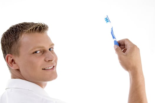 adult caucasian holding toothbrush and posing to camera with white background