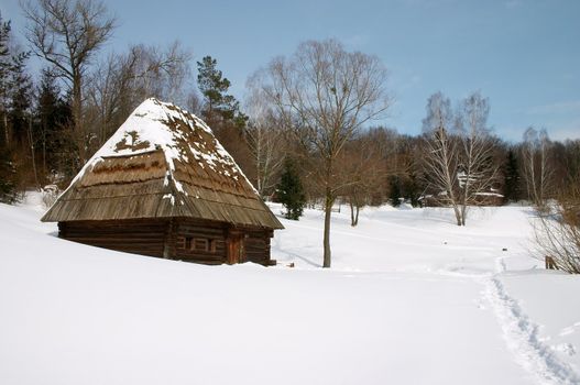 Wooden rural house in the snowy countryside landscape