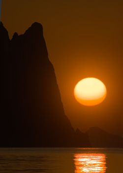 Bright sun over the sea and mountains