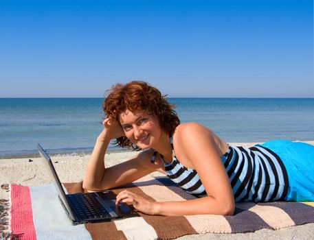 Woman with laptop computer at sea beach