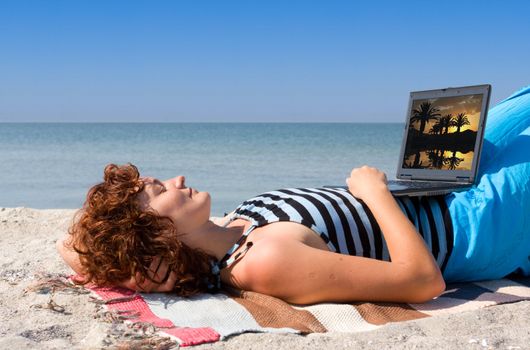 Girl sleep at sea beach with laptop computer
