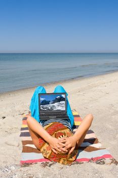 Girl with laptop lie on sand sea beach