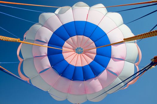 Bright colourful parachute in the blue sky