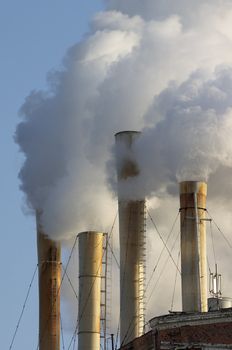 Pipes throwing out a smoke in industrial zone