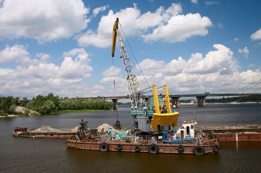 hydraulic dredge on barge in the working river