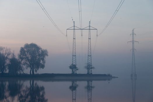 Trees and transmission facilities reflecting in the water