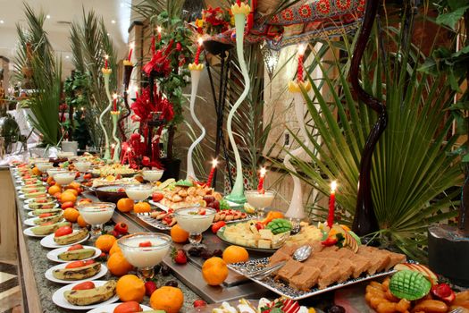 Table with fruit, citrus and dessert in hotel restaurant