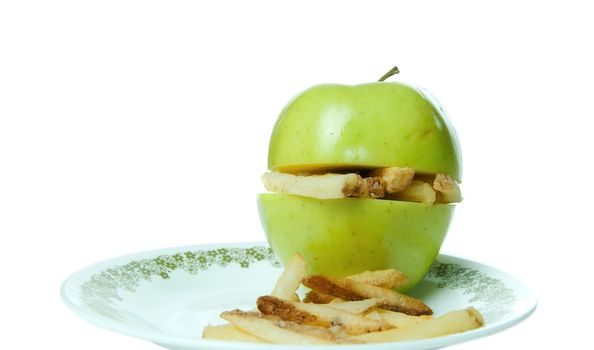 Concept image of unhealthy eating with an apple making a sandwich of french fries.
