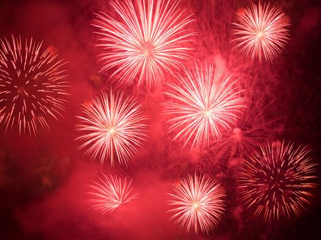 Red fireworks exploding in clouds of smoke