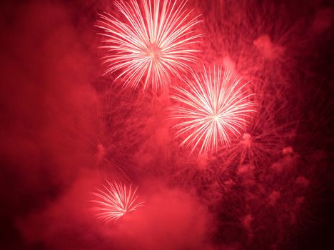 Red fireworks exploding in clouds of smoke