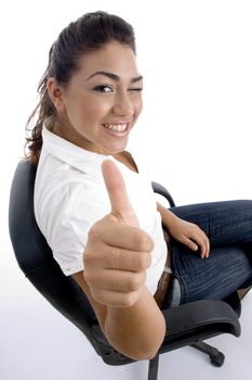 young pretty sitting on the chair and facing to camera against white background