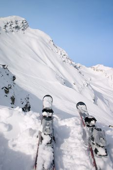 skis in snow on the brink of mountain