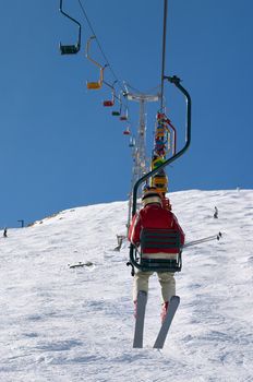 peoples on ski lift in winter mountains