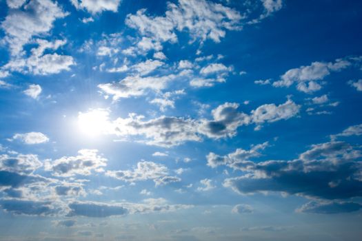 Cloudscape with sun in blue sky