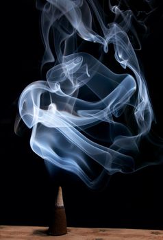 burning incense cone with smoke