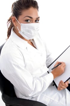 sitting doctor with mask on her mouth and writing board against white background