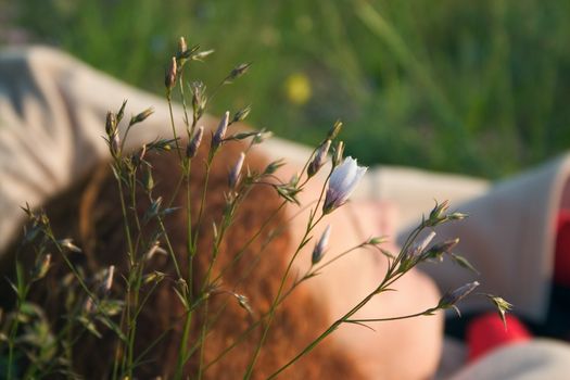 Girl lying on the medow in the middle of flowers