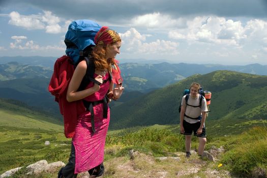 Couple of backpackers hiking in a mountains